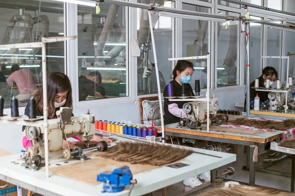 Epoche production team making human hair extensions in the factory workshop