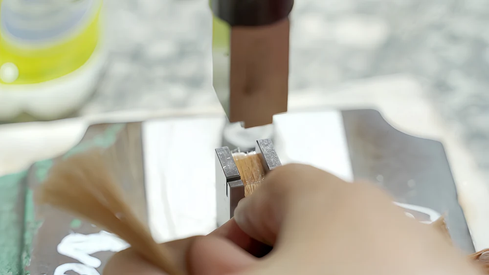 Close-up of keratin tip hair extension bonds being pressed and formed during manufacturing