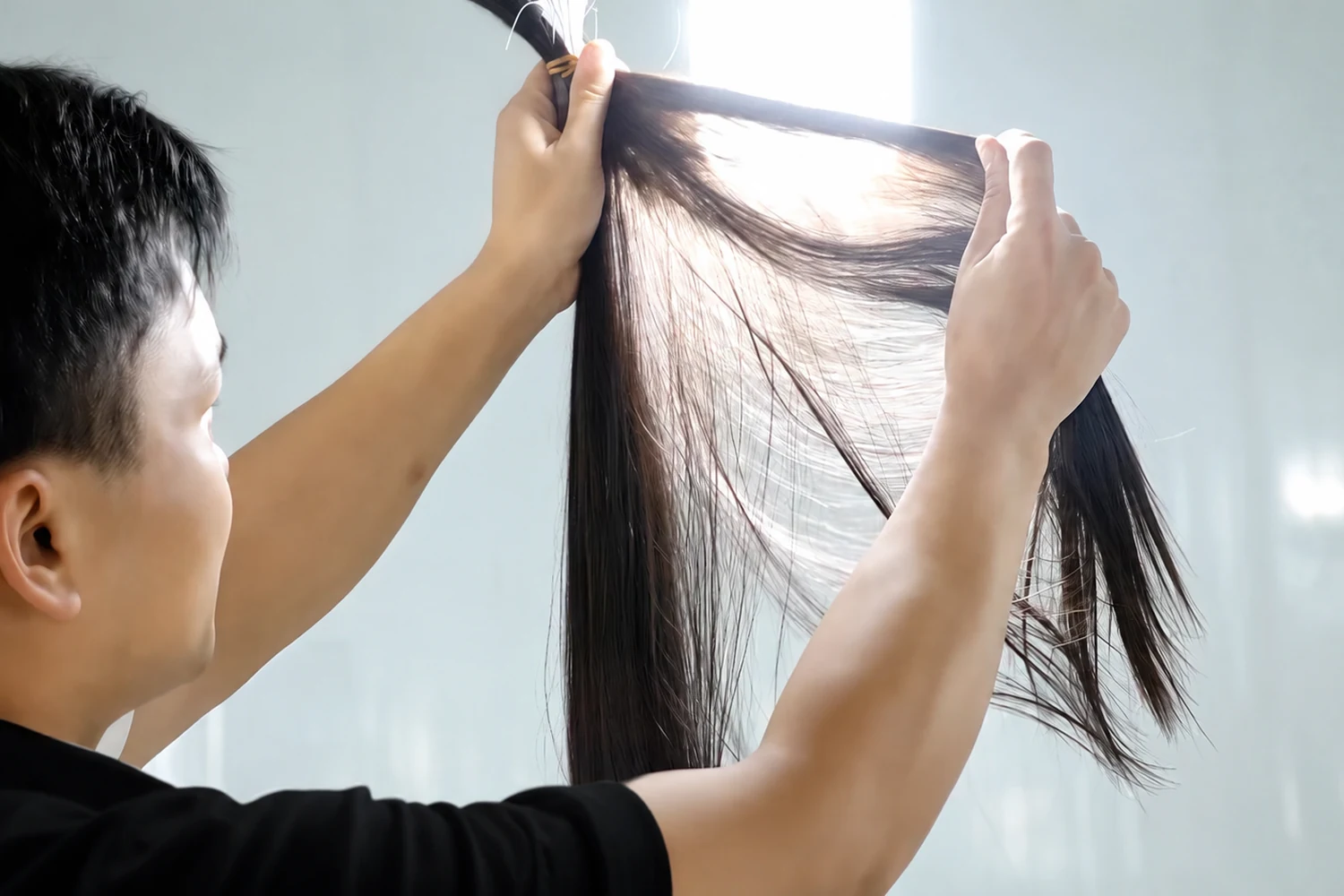 Epoche specialist visually inspecting raw human hair quality and consistency