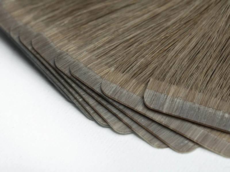 Epoche tape-in human hair extensions showing slim adhesive bands and smooth hair texture