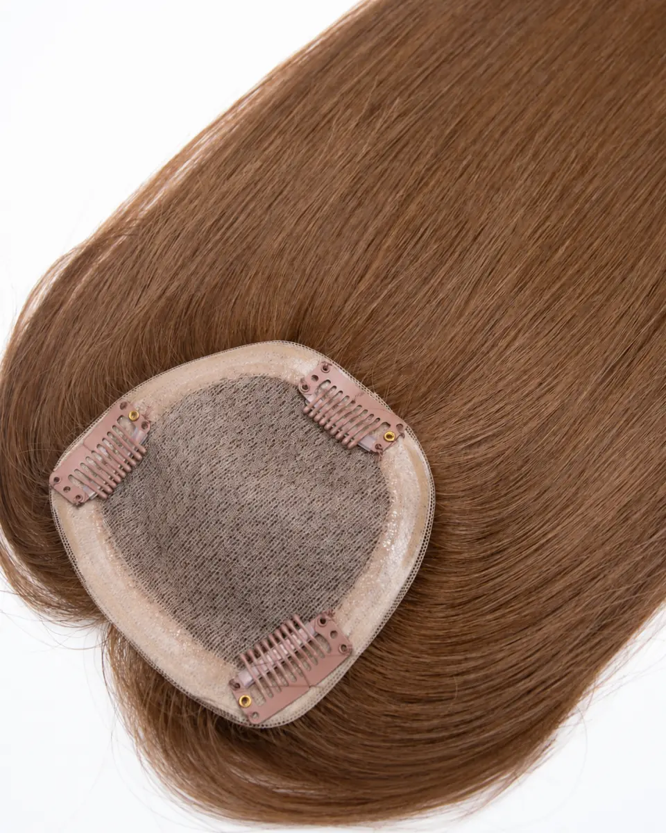 Brown human hair topper showing a pale mesh base, translucent edging and three pink-brown attachment clips.