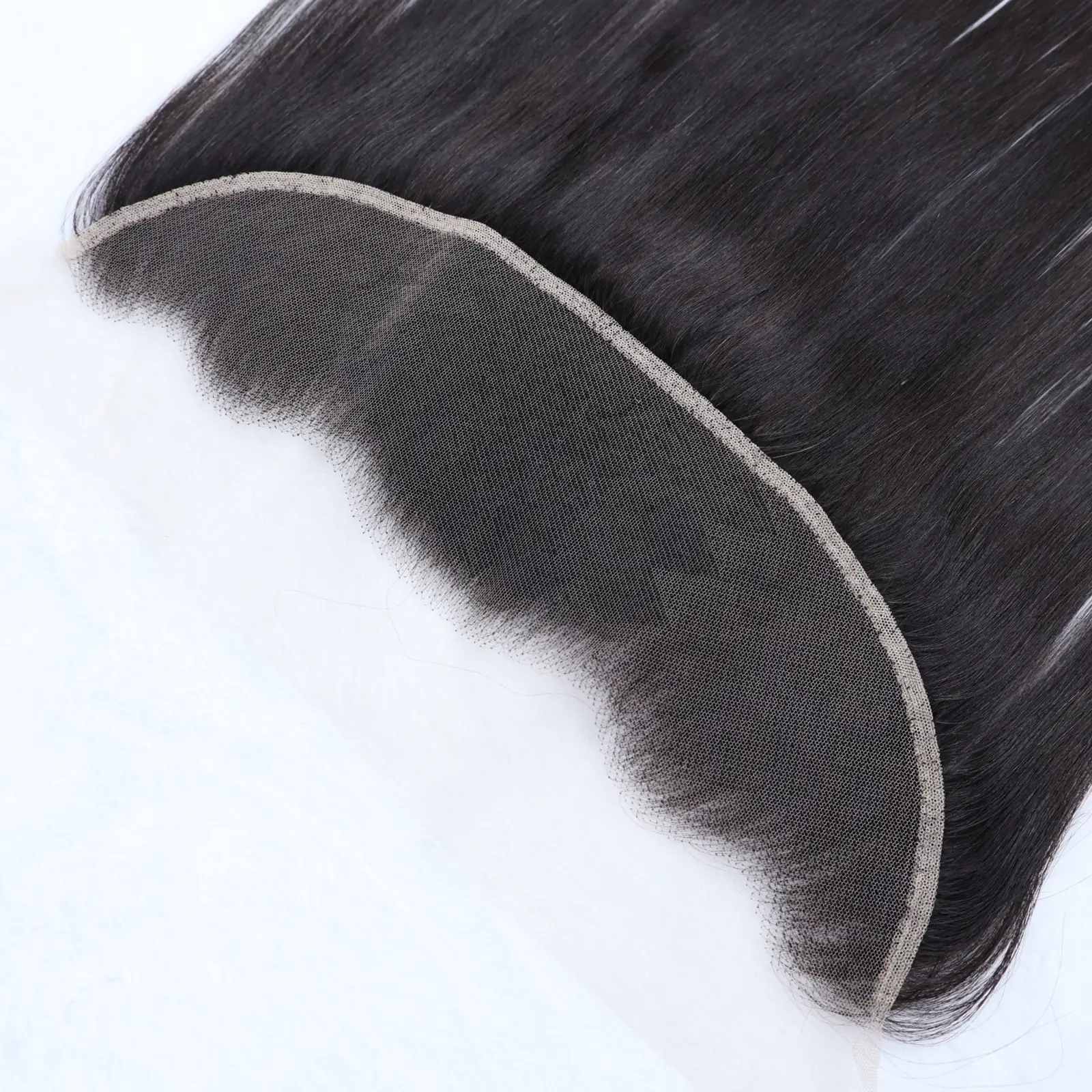 Black hair lace closure laid flat to show the curved mesh base, stitched border and hairline knots.