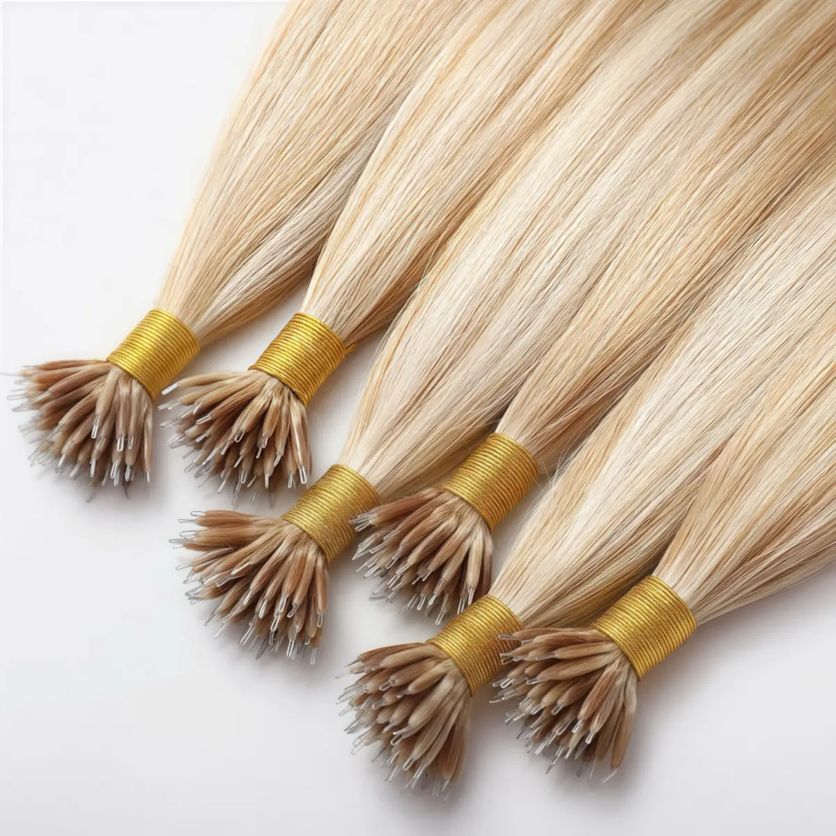 Six blonde micro ring tip hair extension bundles with gold ties, showing slim metal loop tips on a light background.