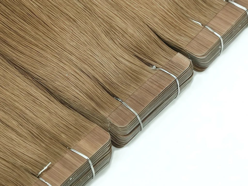 Brown Classic Tape-In Hair Extensions arranged diagonally, showing stacked rectangular tabs secured with silver ties