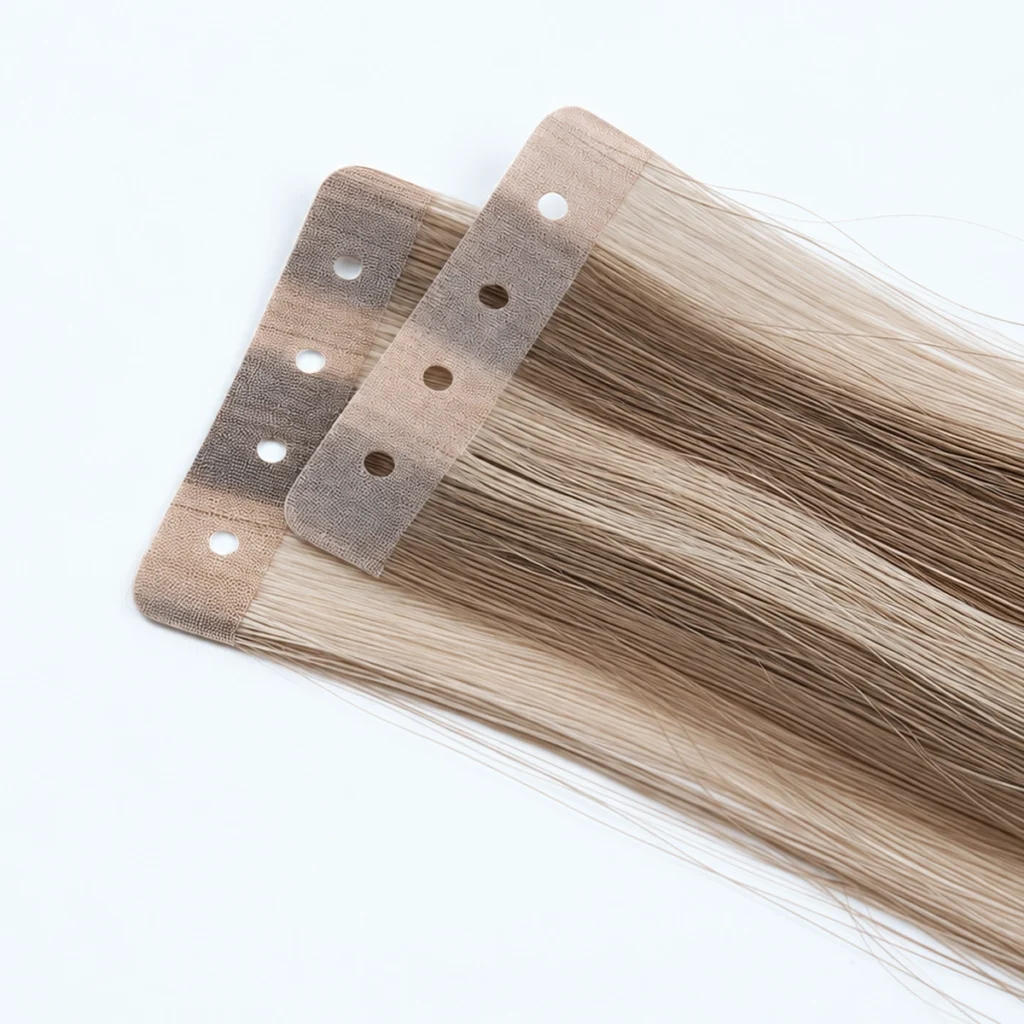 Detailed view of two overlapping Holed Tape-In tabs, each with four round pre-punched holes and a textured surface above blended hair strands.