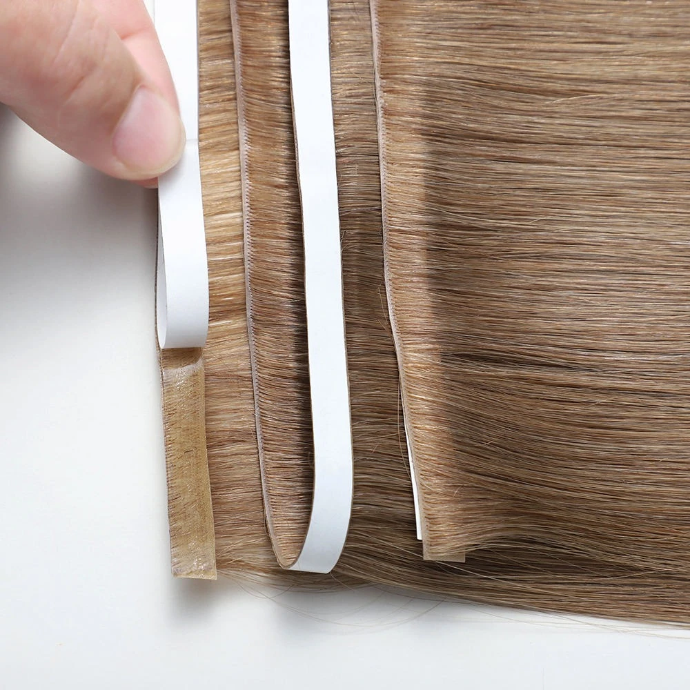 Close-up of a brown invisible weft with white backing partly lifted to reveal the base and edge