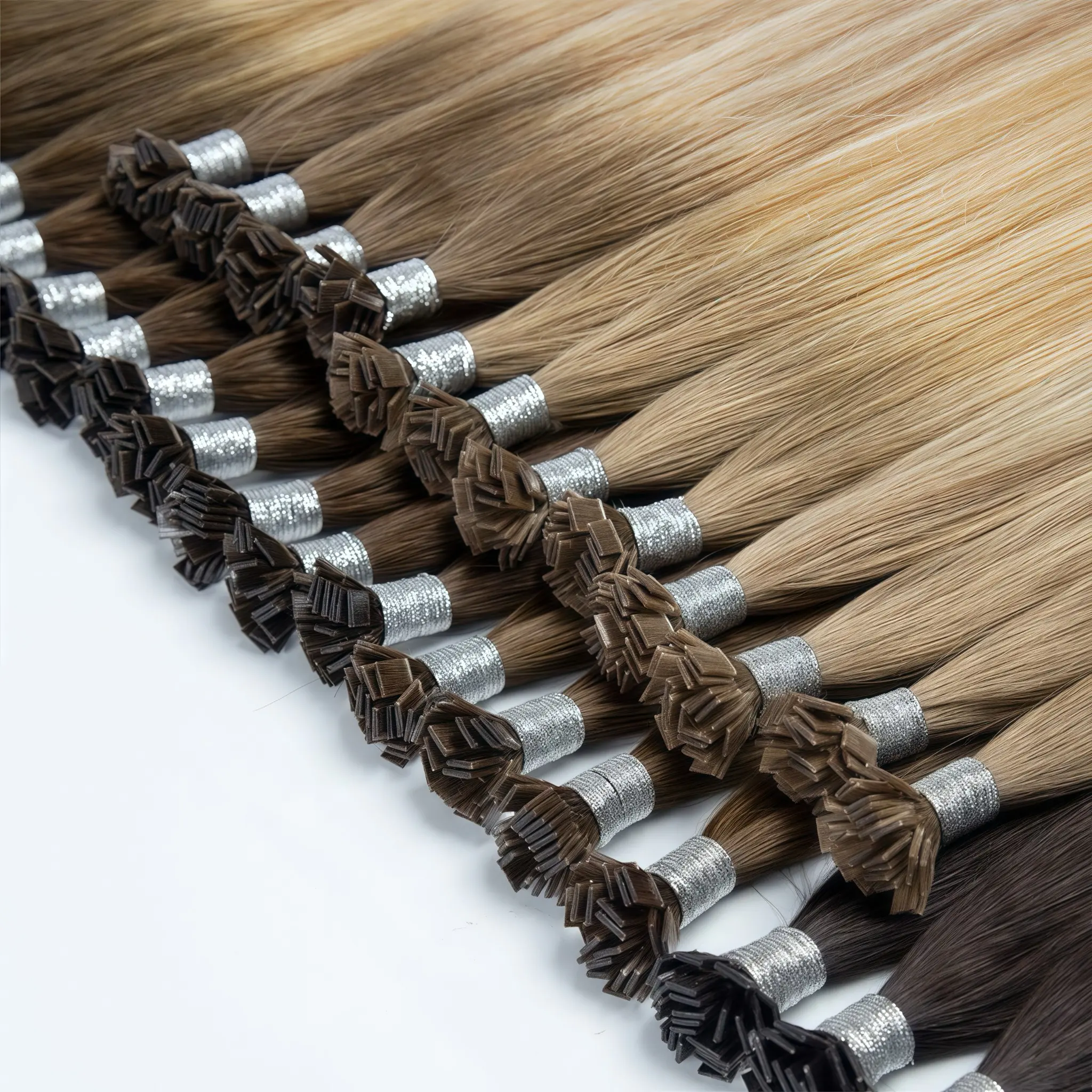 Keratin tip hair extensions in black, brown and blonde shades, arranged in bundles with silver bindings