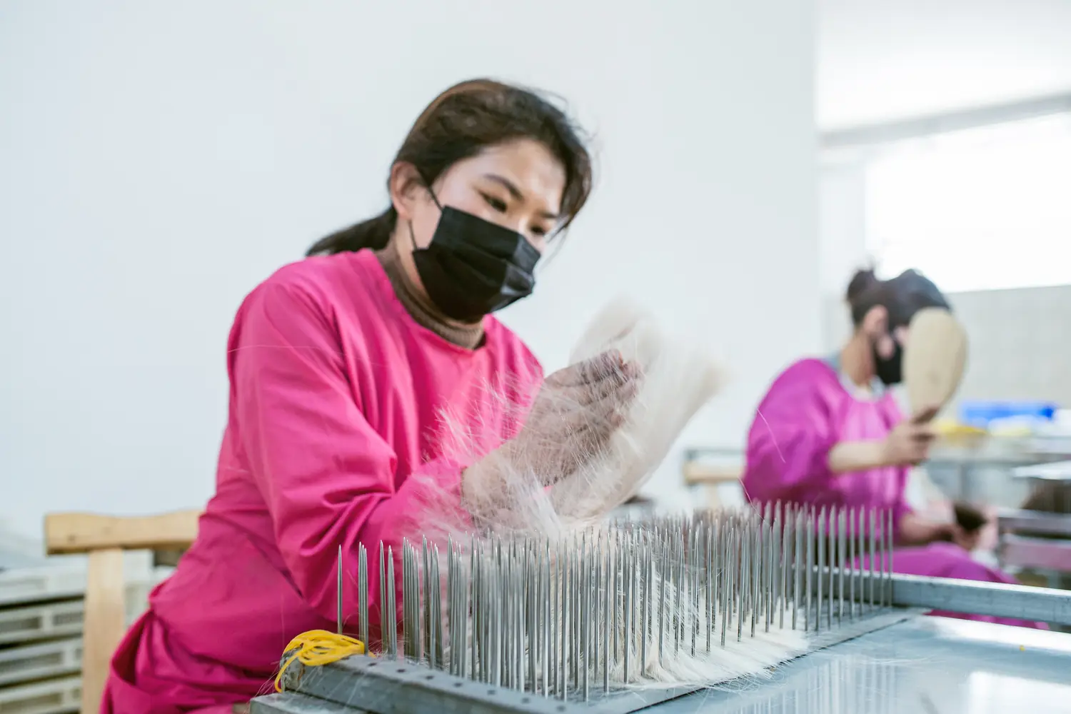 Epoche worker hackling human hair to maintain consistent fiber direction